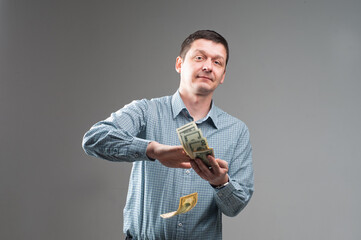 Happy young man with money on light background