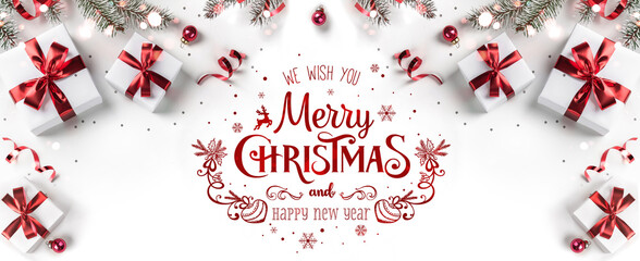 Wall Mural - merry christmas text on white background with gift boxes, ribbons, red decoration, fir branches, bok