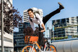© VITTA GALLERY/Westend61 - Cheerful businessman performing stunt on electric bicycle in city