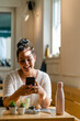 © Giorgio Fochesato/Westend61 - Cheerful young woman using mobile phone while sitting at table in restaurant