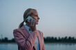 © Joseffson/Westend61 - Beautiful businesswoman talking on mobile phone while looking away against sky at dusk