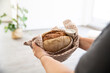 © MiJo/Westend61 - Close-up of mature woman holding bread and salt in new house