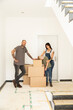 © MiJo/Westend61 - Family with cardboard boxes standing against wall in new apartment