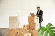 © MiJo/Westend61 - Businessman using laptop on cardboard box while standing in new unfurnished house