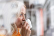 © Robijn Page/Westend61 - Close-up of thoughtful businesswoman drinking coffee in home office seen through window