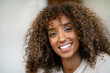 © dirk moll fotografie/Westend61 - Close-up of smiling female entrepreneur with curly hair in office