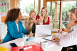 © dirk moll fotografie/Westend61 - Male and female business people discussing over laptop on desk in meeting