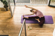 © UWE_UMSTAETTER/Westend61 - Young woman with arms raised practicing yoga on exercise mat at home