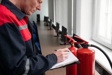 Wall Mural - engineer professional are checking a fire extinguisher and writes data to the check log. fire alarm 