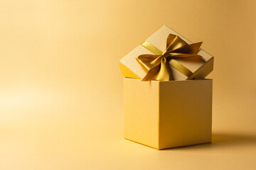 Wall Mural - Golden gift box with shiny satin bow for surprise