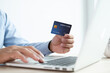 © Orathai - The businessman's hand is holding a credit card and using a laptop for online shopping and internet payment in the office