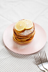 Wall Mural - Homemade Lemon Ricotta Pancakes on a pink plate, side view.