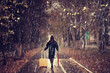 night the girl is walking with an umbrella and a suitcase in the autumn park, the concept of travel, sadness, parting, divorce