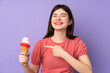 © luismolinero - Young Ukrainian teenager girl holding a cornet ice cream over isolated purple background and pointing it
