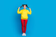 © deagreez - Full length photo of cheerful funny lady hold two tails arms good mood playful wear casual yellow hoodie pullover red trousers sneakers isolated bright blue color background