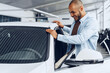 © fotofabrika - Portrait of a handsome happy African American man sitting in his newly bought car