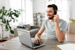© Syda Productions - remote job, technology and people concept - happy smiling man with headset and laptop computer having video conference at home office