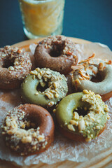 Fresh baked pistachio donuts with nuts.Doughnuts in bakery acfe.Sweet pastry products cooked for lunch break with natural ingredients.Delicious glazed doughnut set prepared for breakfast meal