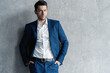 © opolja - Handsome man wear blue suit isolated on grey background