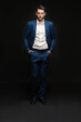 © opolja - Handsome man wear blue suit isolated on black background