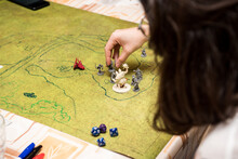 Girl With Glasses Playing Role Game Dungeons And Dragons, Miniatures And Dices On The Green Field.