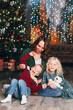 © irina_timokhina - Cute mother with daughter and son posing at the Christmas tree