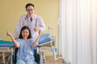 © Avirut S. - Healthcare and Treatment Concept. Young Asian female patient smiley face lifts hand up fighting with illness on wheelchair. Doctor and Patient showing fighting spirits over illness in hospital room.