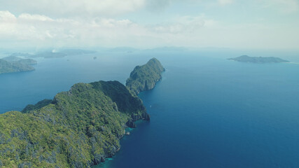 Tropical highland island aerial view at blue ocean bay. Asia mountainous isle with exotic nature variety scape. Cinematic summer scenery of Palawan islet, Philippines. Soft light drone shot