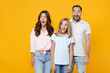 © ViDi Studio - Surprised young happy parents mom dad with child kid daughter teen girl in basic t-shirts keeping mouth open looking aside isolated on yellow background studio portrait. Family day parenthood concept.
