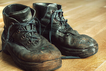 Old worn-out workman's shoes. Shoes that require repair or replacement