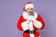 © ViDi Studio - Cheerful gray-haired Santa Claus man in Christmas hat red suit coat white gloves glasses biting chocolate bar isolated on violet background studio. Happy New Year celebration merry holiday concept.