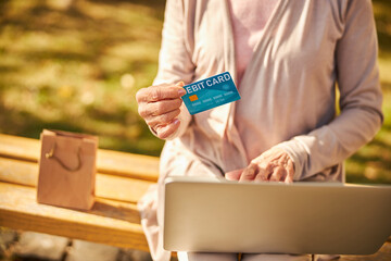 Pensioner taking a debit card in her hand