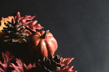 Sticker - Red autumn leaves with pumpkin decoration on black background for fall season concept.