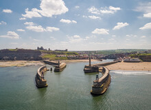 Aerial View Of East And West Piers Each With A Lighthouse And Beacon, Whitby, UK.