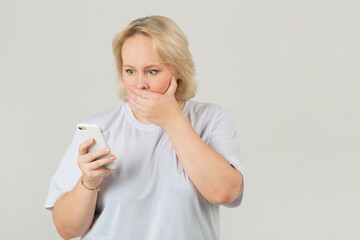 Wall Mural - beautiful young plump female in a white t-shirt with a phone in her hand