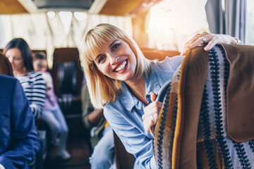 Happy beautiful blond woman traveling by bus.