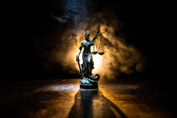 the statue of justice - lady justice or iustitia / justitia the roman goddess of justice on a dark f
