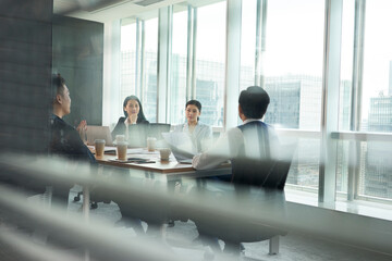 team of asian corporate executives discussing business in conference room