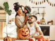 © JenkoAtaman - happy multiethnic family mom, dad and son have fun and celebrate Halloween at home.
