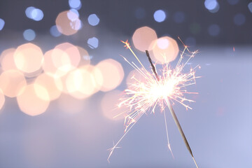 Wall Mural - Beautiful Christmas sparkler on dark background with blurred lights