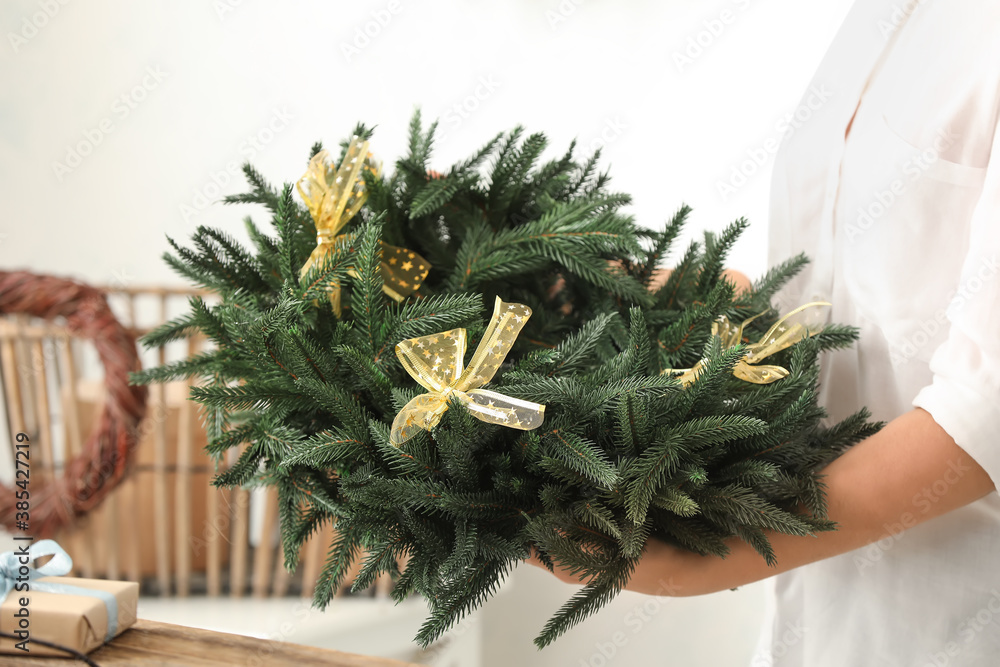 Woman with beautiful Christmas wreath, closeup
