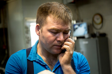 Wall Mural - Close-up portrait of a man in the workplace with a mobile phone