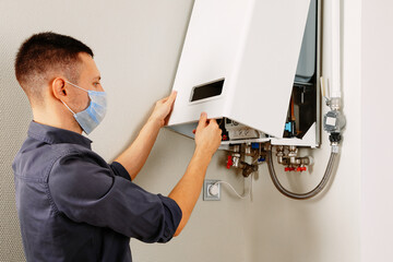 a man repairing a boiler in a medical mask