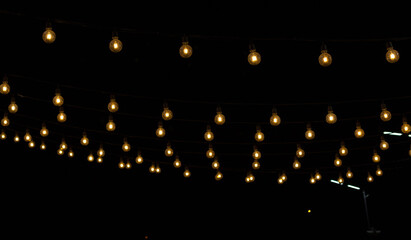 Wall Mural - a row of light bulbs hanging on the street at night