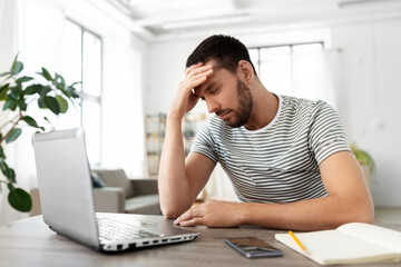 Poster - remote job, technology and people concept - stressed young man with laptop computer having headache at home office