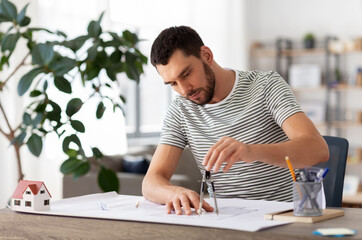 Poster - architecture, building, construction and real estate concept - male architect with compass measuring blueprint on table working at home office