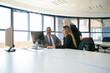 © Mangostar - Company managers discussing solution. Businesspeople gathering in meeting room, watching content on computer monitor together. Business communication or teamwork concept