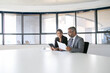 © Mangostar - Company executives analyzing and discussing reports. Two business colleagues sitting together, looking at document, holding tablet and talking. Wide shot. Communication concept