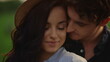 © stockbusters - Charming man hugging woman behind outdoors. Girl and guy spending date in park