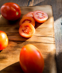 Red tomatoes,sliced tomatoes on a dark old wooden table,close-up